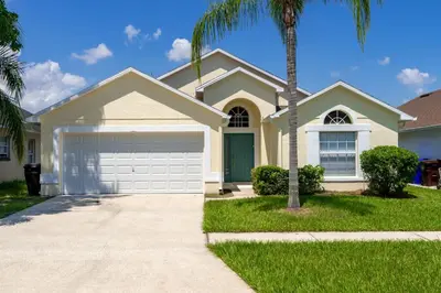 a house with a palm tree in front of it at Near Disney Private Pool 4 Bedrooms in Kissimmee