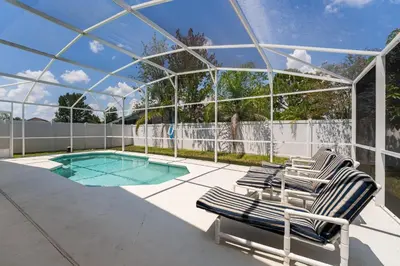 a pair of lounge chairs and a swimming pool at Near Disney Private Pool 4 Bedrooms in Kissimmee