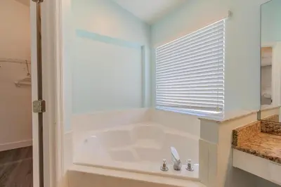 a white tub in a bathroom with a window at 4-Bed Home Near Disney Private Pool in Kissimmee