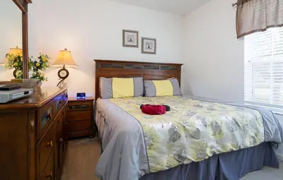 a bedroom with a bed with a red item on it at DREAM Vacation BY A3G in Orlando