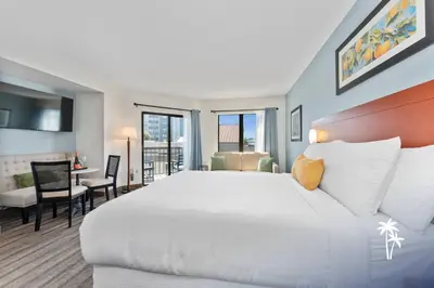 a bedroom with a large white bed and a desk at Relaxing Central Condo with Balcony 7 Min to Universal in Orlando