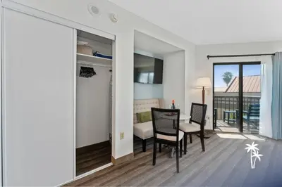 a living room with a table and chairs and a balcony at Relaxing Central Condo with Balcony 7 Min to Universal in Orlando