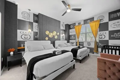 a bedroom with two beds and a ceiling fan at 12BR Disney Home | Sleeps 30+, GameRoom, POOL/SPA! in Kissimmee