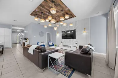 a living room with two brown couches and a tv at 12BR Disney Home | Sleeps 30+, GameRoom, POOL/SPA! in Kissimmee