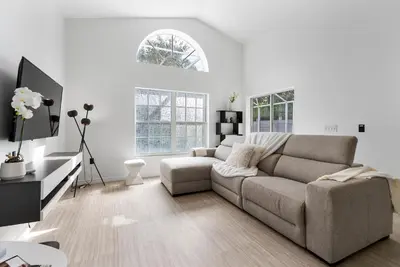 a white living room with a couch and a tv at 4BD Family Pool Home, Near Disney & Workspace in Orlando