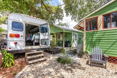 a rv parked in front of a green house at Cozy 3BR Retreat - Near Bars Zoo & Lake Trails in Sanford