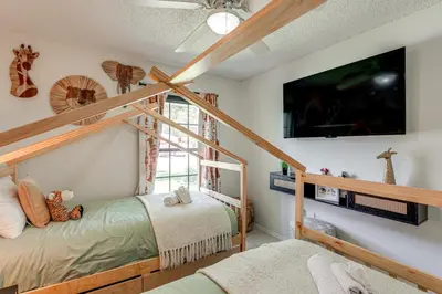 a room with two beds and a flat screen tv at Disney Getaway with Private Hot Tub 14 Mi to Parks in Kissimmee