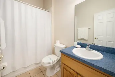 a bathroom with a white toilet and a sink at Casa 5 Quartos Vista Lago – Perto da Disney! in Kissimmee