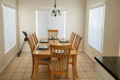 a dining room with a wooden table and chairs at Casa 5 Quartos Vista Lago – Perto da Disney! in Kissimmee
