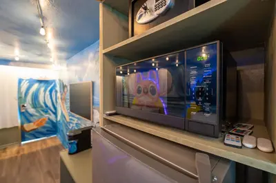 a tv on a shelf with a video game at Surf and Sun Stitch Studio Kissimmee in Kissimmee