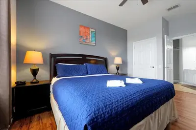 a bedroom with a blue bed with two towels on it at Vista Cay Resort Minutes to Parks & Magic! in Orlando