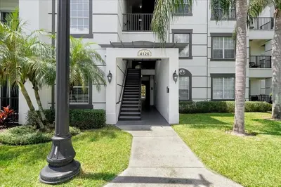 a building with a stairway leading into a building with palm trees at Vista Cay Resort Minutes to Parks & Magic! in Orlando