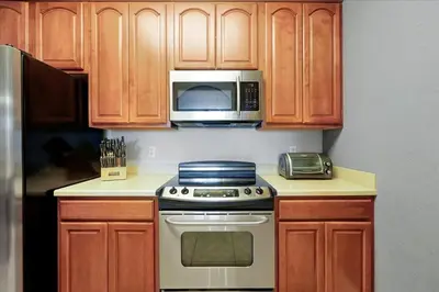 a kitchen with a stove and a microwave at Vista Cay Resort Minutes to Parks & Magic! in Orlando