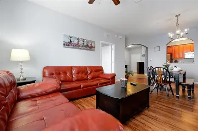 a living room with a leather couch and a table at Vista Cay Resort Minutes to Parks & Magic! in Orlando