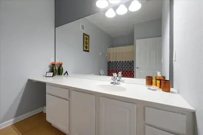 a white bathroom with a sink and a mirror at Vista Cay Resort Minutes to Parks & Magic! in Orlando