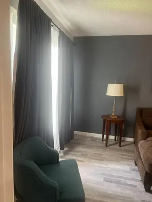 a living room with a green chair and a window at Condo Near Disney No Resort Fee Free Parking in Orlando