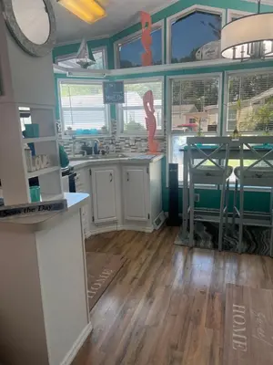 a kitchen with white cabinets and a table in it at Cozy Private Cottage Only 5 miles from Disney in Kissimmee
