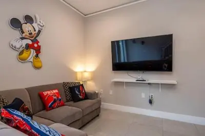 a living room with a couch and a flat screen tv at 4 Luxurious Suites Near Theme Parks and Downtown in Orlando