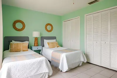 two beds in a room with green walls at Excelente Refúgio em Indian Wells c/ Piscina Priv! in Kissimmee