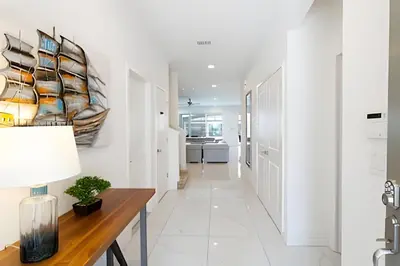a hallway with white walls and a table with a lamp at Luxuosa Villa 9 Suítes c/ Piscina Sonoma Resort in Kissimmee