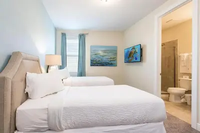 a bedroom with two white beds and a bathroom at Luxury 9-Bedroom Villa with Pool Near Disney in Orlando