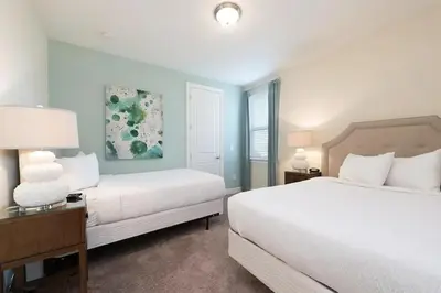 a white bedroom with two beds and a window at Luxury 9-Bedroom Villa with Pool Near Disney in Orlando
