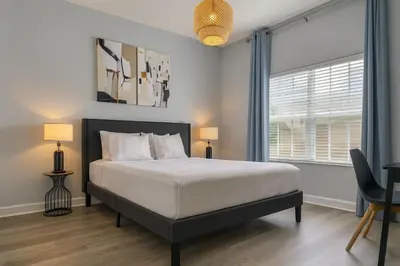 a bedroom with a bed and a large window at Casa Disney 5 Quartos c/ Piscina – 13 Pessoas in Kissimmee