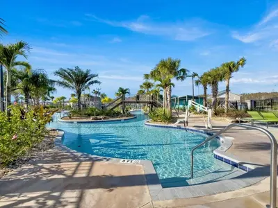 a swimming pool with palm trees and a bridge at Casa Disney 5 Quartos c/ Piscina – 13 Pessoas in Kissimmee