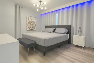 a bedroom with a bed and a chair in it at Casa Disney 5 Quartos c/ Piscina – 13 Pessoas in Kissimmee