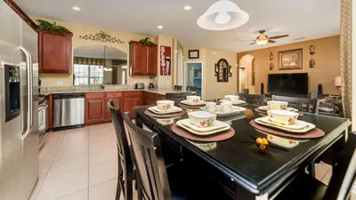 a kitchen and dining room with a table with chairs at Private 6 Bed 4 Bath Villa- Cozy family vacation home sleeps up to 12 guests in Orlando