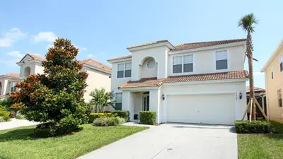 a white house with a garage and a palm tree at Urban 6 Bed 4 Bath Villa- Perfect stay while exploring Orlando,Florida in Orlando