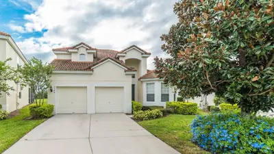 a white house with a garage in a yard at Urban 5 Bed 5 Bath Villa- Perfect stay while exploring Orlando,Florida in Orlando