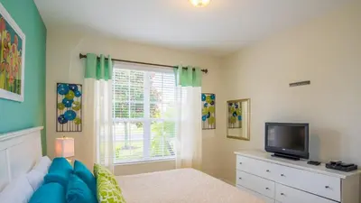 a bedroom with a bed and a tv and a window at Urban 4 Bed 4 Bath Villa- Perfect stay while exploring Orlando,Florida in Orlando