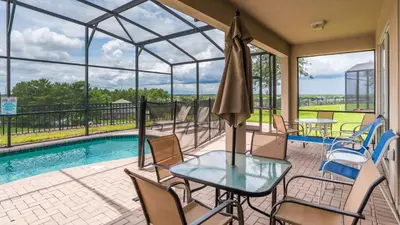 a patio with a table and chairs and a pool at Urban 4 Bed 4 Bath Villa- Perfect stay while exploring Orlando,Florida in Orlando