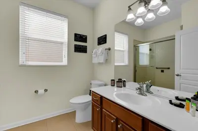 a bathroom with a sink and a toilet and a mirror at Urban 6 Bed 4 Bath Villa- Perfect stay while exploring Orlando,Florida in Orlando