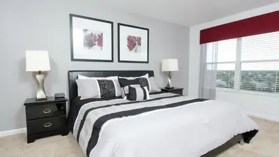 a bedroom with a large bed with two lamps and a window at Urban 6 Bed 4 Bath Villa- Perfect stay while exploring Orlando,Florida in Orlando