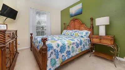 a bedroom with a bed and a dresser with a lamp at Urban 3 Bed 2 Bath Condo- Perfect stay while exploring Orlando,Florida in Orlando