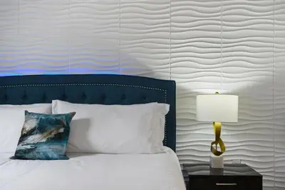 a bedroom with a bed with a blue headboard and a lamp at Mansão 9 Quartos com Cinema, Piscina e SPA in Kissimmee