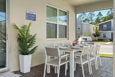 a white table with chairs and a plant on a patio at Mansão 9 Quartos com Cinema, Piscina e SPA in Kissimmee