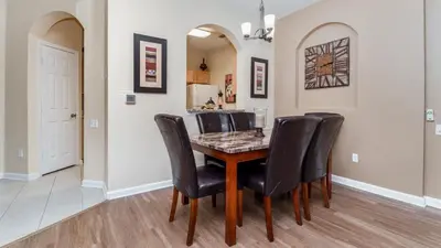 a dining room with a table and black chairs at Contemporary 3 Bed 2 Bath Condo- Near Walt Disney World W/ great amenities in Orlando