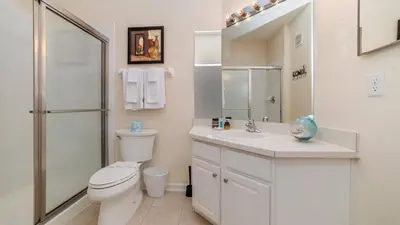 a white bathroom with a toilet and a sink at Contemporary 3 Bed 2 Bath Condo- Near Walt Disney World W/ great amenities in Orlando