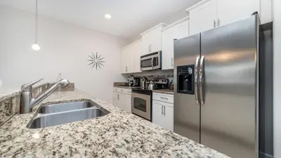 a kitchen with stainless steel appliances and granite counter tops at Private 4 Bed 3 Bath Townhome - Cozy family vacation home sleeps up to 10 guests in Kissimmee