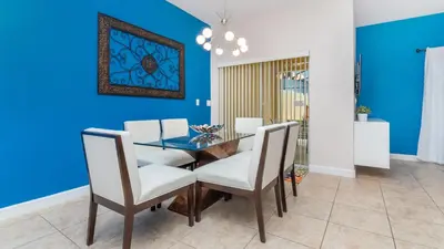 a dining room with blue walls and a table and chairs at Private 4 Bed 3 Bath Townhome - Cozy family vacation home sleeps up to 10 guests in Kissimmee