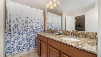 a bathroom with a sink and a blue and white shower curtain at Private 4 Bed 3 Bath Townhome - Cozy family vacation home sleeps up to 10 guests in Kissimmee