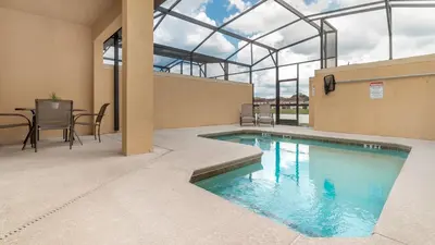 a swimming pool in a building with a table and chairs at Private 4 Bed 3 Bath Townhome - Cozy family vacation home sleeps up to 10 guests in Kissimmee