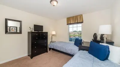 a bedroom with a bed and a dresser at Contemporary 4 Bed 3 Bath Townhome - Near Walt Disney World W/ great amenities in Kissimmee