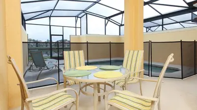 a patio with a table and chairs on a balcony at Contemporary 4 Bed 3 Bath Townhome - Near Walt Disney World W/ great amenities in Kissimmee