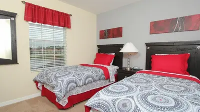 two beds in a bedroom with red pillows and a window at Contemporary 4 Bed 3 Bath Townhome - Near Walt Disney World W/ great amenities in Kissimmee
