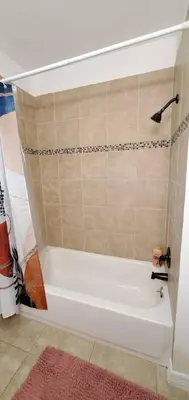 a white bath tub in a bathroom with a pink rug at Bungalow DT by Lake Eola KIA center Sleeps 12 in Orlando