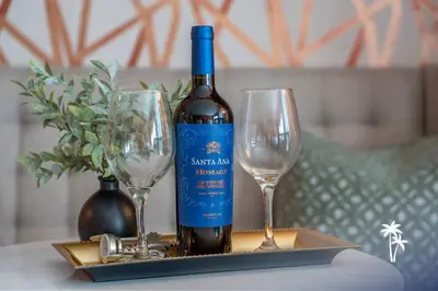 a bottle of wine and two wine glasses on a table at Boho Chic Garden Condo 7 Min to Universal Parks in Orlando